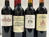 four bottles of wine are lined up in a row on a table
