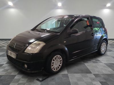 la photo d'une petite voiture noire garée sur un sol en damier
