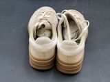 pair of beige shoes with laces on them sitting on a black surface