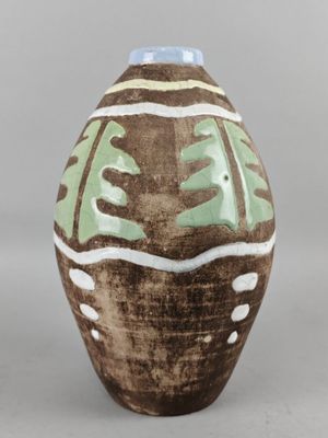 un vase marron orné de motifs verts et blancs
