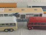 quatre petits bus posés sur une surface blanche