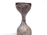 a gray vase that is sitting on a white surface