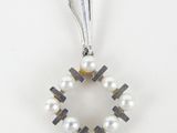 a white pearl and silver cross pendant on a white background