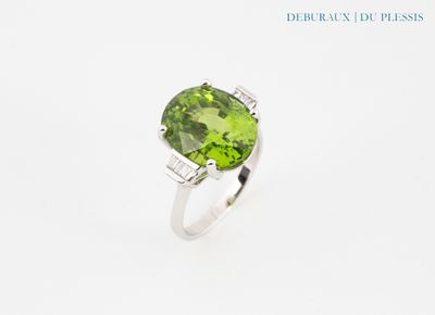 Gros plan sur une bague ornée d'une pierre verte