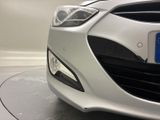 the front end of a white car with a blue license plate on it
