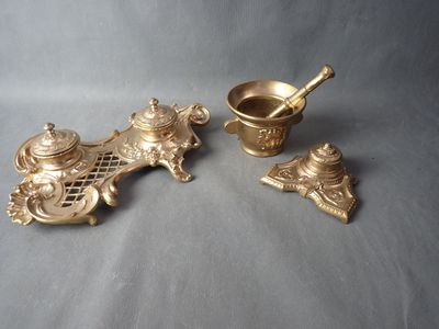 three pieces of brass are sitting on a gray surface