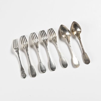 six fourchettes et cuillères sont disposées en ligne sur une surface blanche