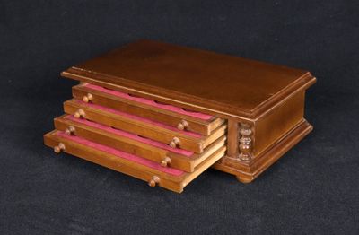 a small wooden box with pink drawers on a black background