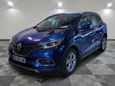 une voiture bleue est garée sur le sol à carreaux d'un garage