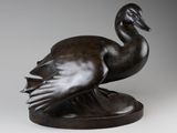 bronze sculpture of a duck on a pedestal on a gray background