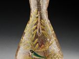 un vase en verre avec un oiseau sur une table