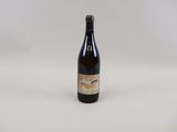 the bottle of beer is sitting on a white surface