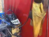 un poste à souder fixé à un mur rouge