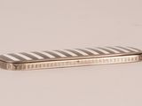 a silver and black striped case sitting on a white surface
