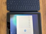 une tablette posée sur un clavier, à côté d'un ordinateur portable