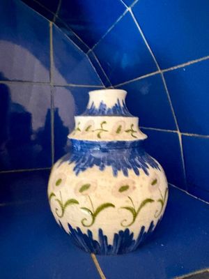 un vase bleu et blanc posé sur un plan de travail carrelé de bleu