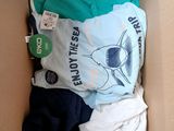 a cardboard box filled with clothes and a t - shirt