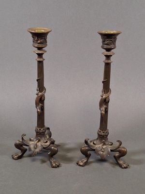 pair of antique bronze candlesticks with lion heads on the bases