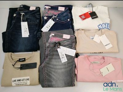 several pairs of jeans and t - shirts are laid out on a table
