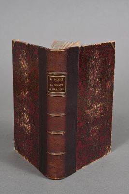 an old book with a brown cover sitting on top of a table