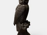 an owl statue sitting on top of a wooden stump