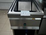 un lave-vaisselle en acier inoxydable posé au milieu d'un sol carrelé