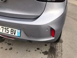 the rear end of a silver car parked on the side of the road