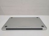 a silver tablet computer sitting on top of a white table