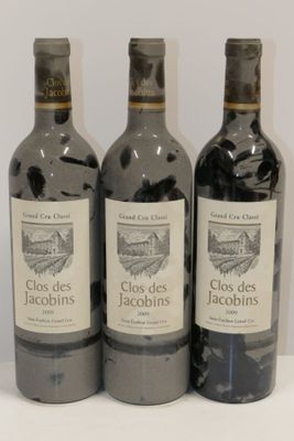 trois bouteilles de vin posées sur une table blanche