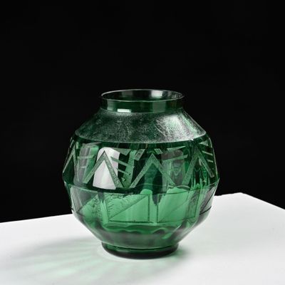 un vase en verre vert posé sur une table blanche