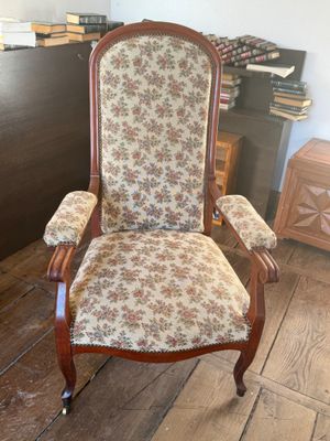 a chair that has a floral upholstered seat on it