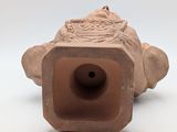 a clay object that is sitting on a white surface