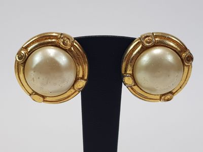 a close up of a pair of earrings on a stand