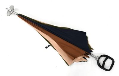 un parapluie noir et marron et une paire de ciseaux posés sur une surface blanche