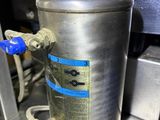 a metal container that has a blue handle on it
