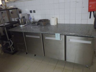 une petite cuisine équipée d'une cuisinière, d'un évier et d'un lave-vaisselle