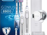 three electric toothbrushes sitting next to a box of toothpaste