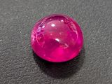 a close up of a pink stone on a black surface