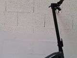 an electric scooter parked against a brick wall in front of a white wall