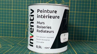 un pot de peinture posé sur un tapis de découpe