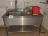 a stainless steel sink in a kitchen with a red bucket