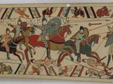 a tapestry with a picture of a group of people riding horses