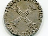 une vieille pièce d'argent sur laquelle figure une croix sur un fond blanc
