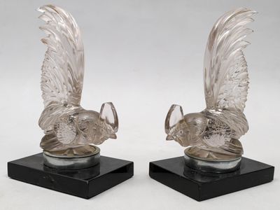 paire de figurines de dindes en verre transparent posées sur des socles en marbre noir