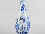vase bleu et blanc orné de personnages, posé sur un socle, sur fond gris