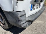 a car that has been dented and is parked on the side of the road