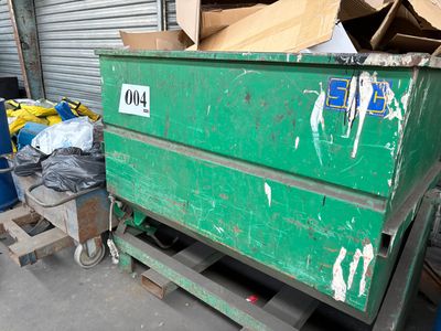 une benne verte qui se trouve dans un garage