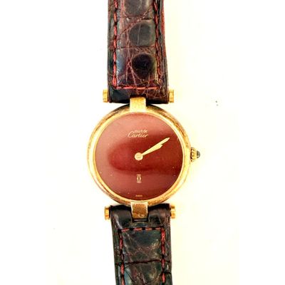 un gros plan d'une montre-bracelet au cadran rouge