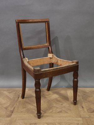 une vieille chaise en bois posée sur un parquet en bois dur