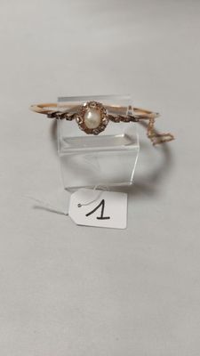 un gros plan d'une bague sertie d'une perle, posée sur une table